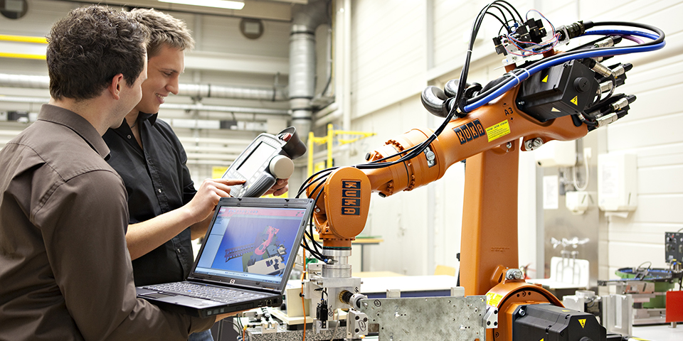 Orange KUKA-Roboter, die Teil einer autonomen Montagezelle sind (Industrie 4.0)