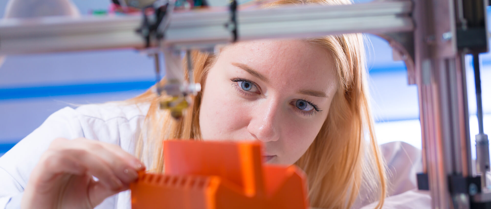 Eine Studentin der Fachrichtung Werkstoff- und Prozesstechnik bearbeitet ein gefertigtes Teil aus dem 3D-Drucker